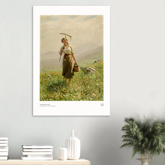 Hans Dahl’s A Young Woman in the Meadow (1894) poster with white border, displayed above books and white ceramics beside a plant.
