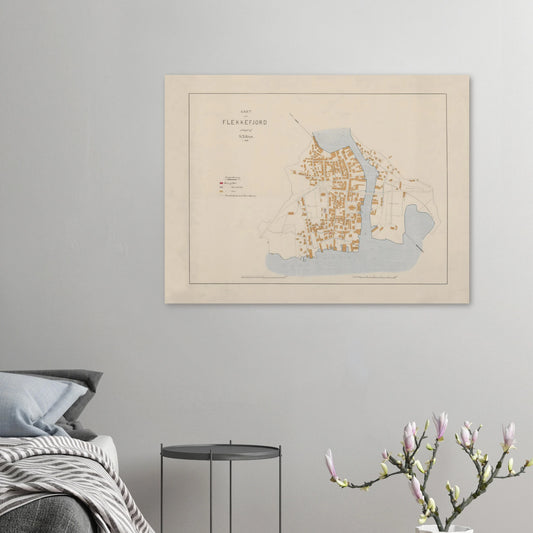 Flekkefjord map print displayed on a grey bedroom wall above a small dark side table, beside bedding and flowering branches.