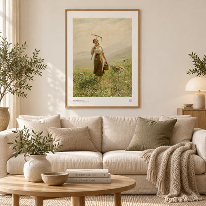 Hans Dahl’s A Young Woman in the Meadow (1894) poster with white border, displayed above books and white ceramics beside a plant.